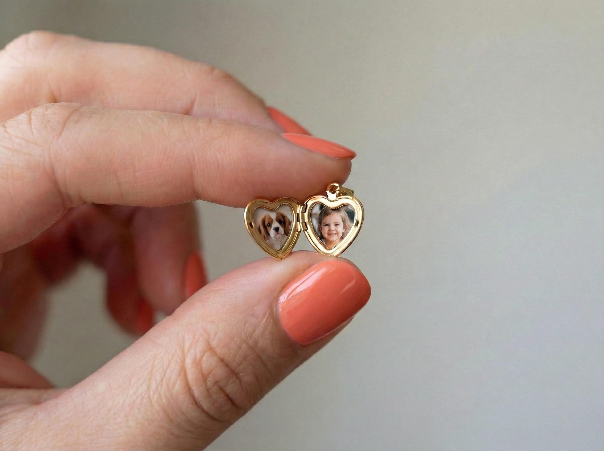 small heart locket pendant held between fingers showing delicate size minimal gold photo locket necklace