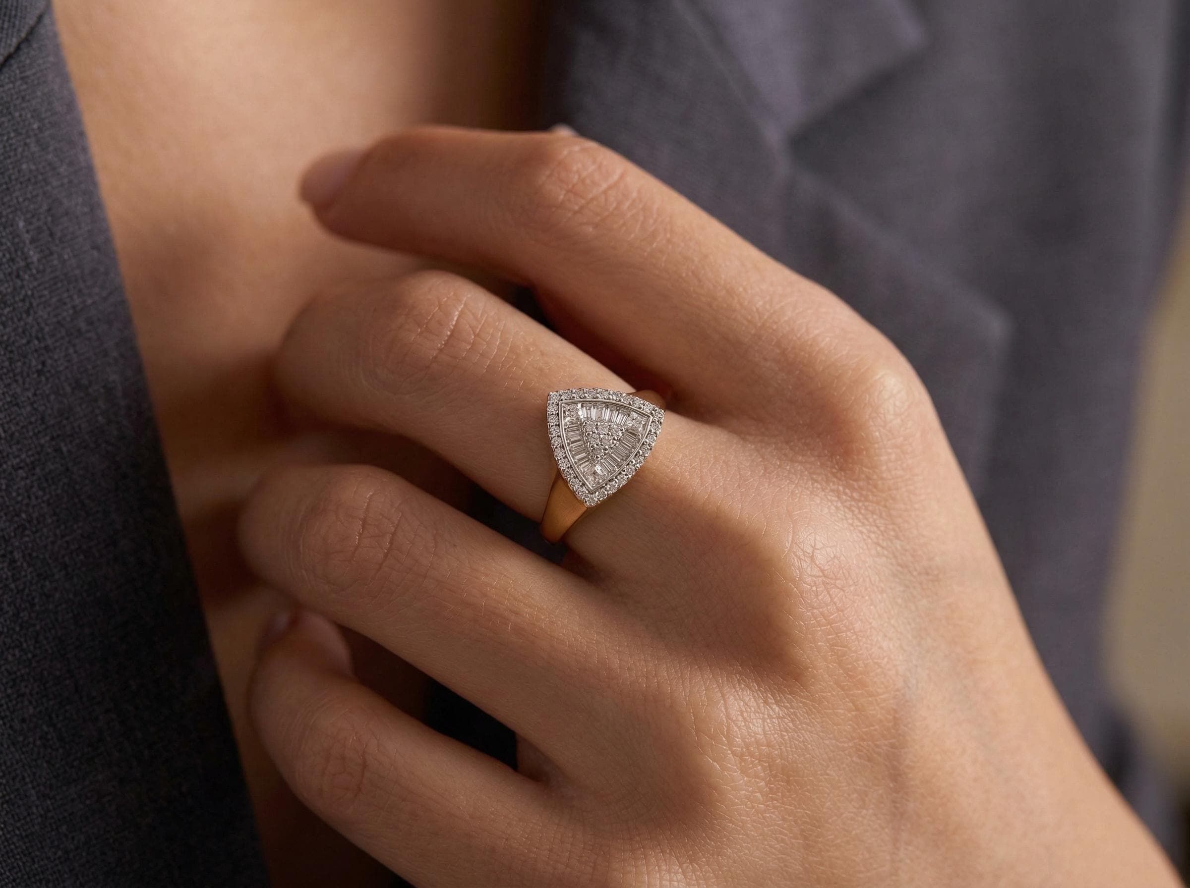 Diamond baguette triangle ring worn on hand, solid 14k gold geometric statement design with pavé halo detail, elegant fine jewelry look.