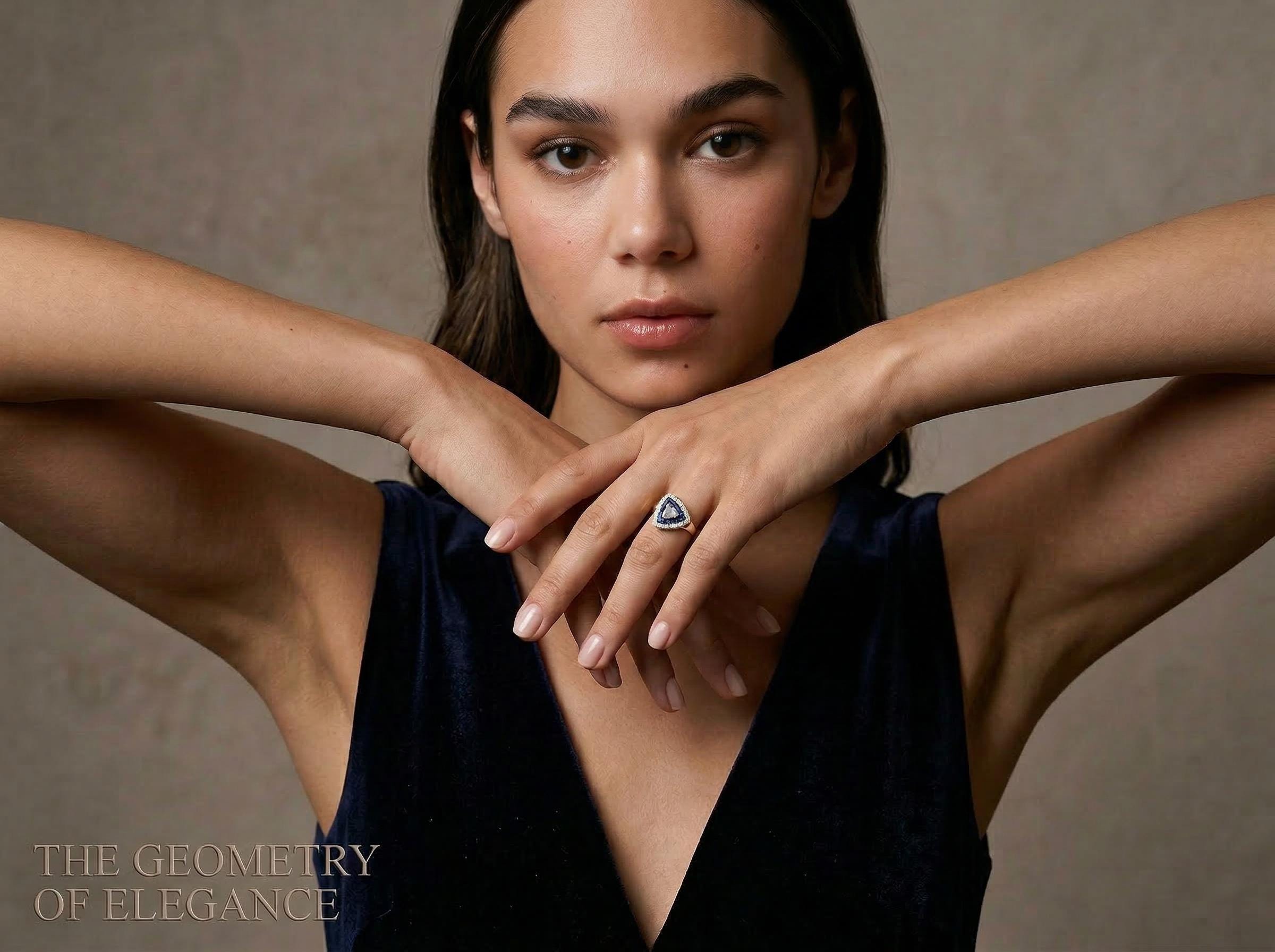 14k solid gold sapphire ring with triangle baguette blue stones and diamond halo worn on hand as geometric statement ring.